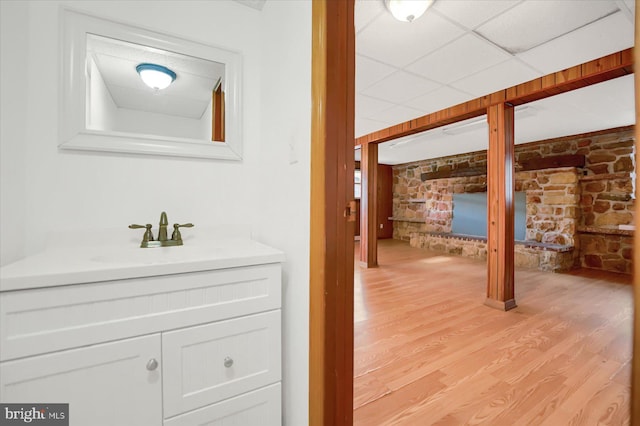 bathroom featuring a paneled ceiling, wood-type flooring, and vanity