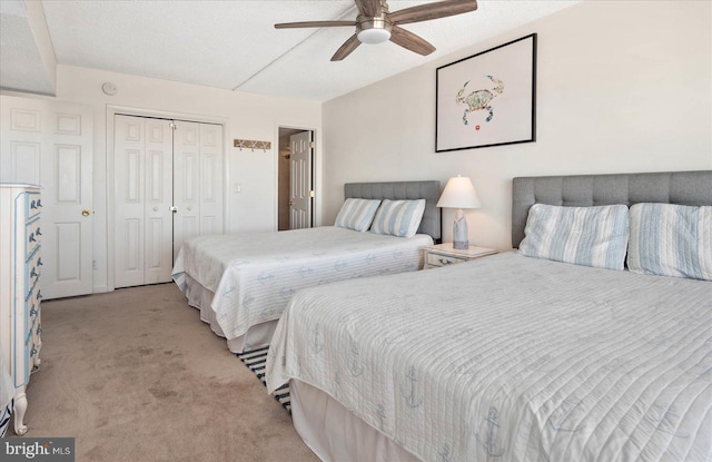 carpeted bedroom with a textured ceiling, ceiling fan, and a closet