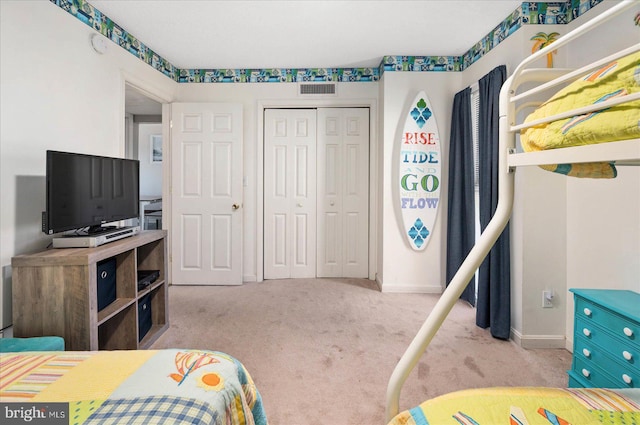 bedroom with light carpet and a closet