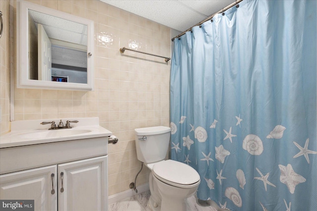 bathroom featuring toilet, vanity, tile walls, and a shower with curtain