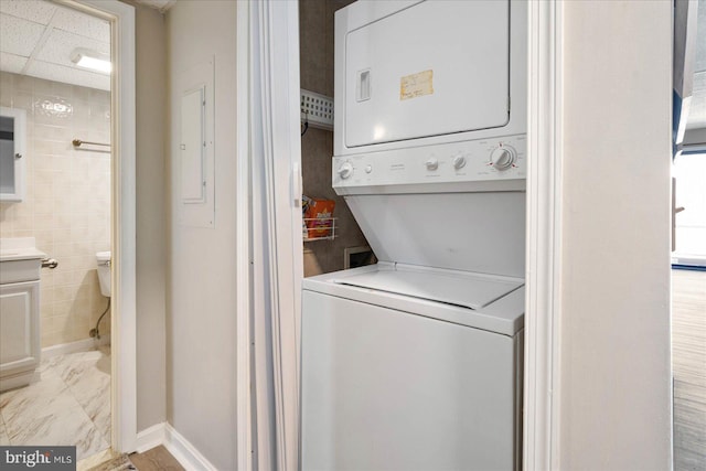 washroom featuring stacked washer and clothes dryer