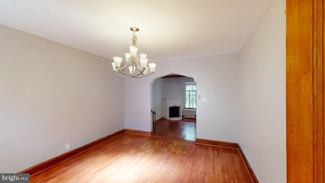 unfurnished dining area with an inviting chandelier and hardwood / wood-style floors