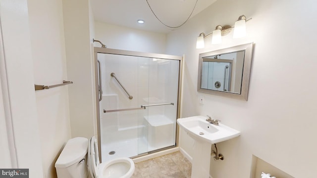 bathroom with toilet and a shower with shower door