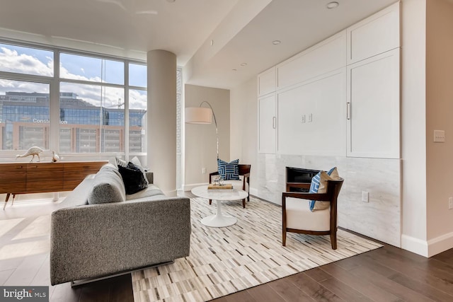 sitting room with hardwood / wood-style floors and a premium fireplace