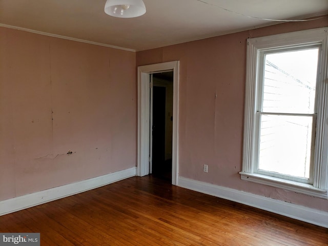 unfurnished room featuring ornamental molding and dark hardwood / wood-style floors