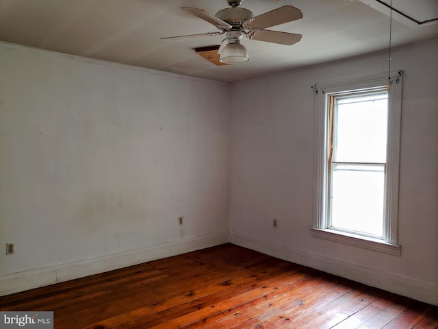 spare room featuring hardwood / wood-style flooring, ornamental molding, a healthy amount of sunlight, and ceiling fan