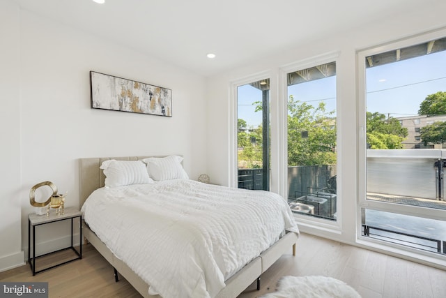 bedroom with access to outside and light hardwood / wood-style flooring