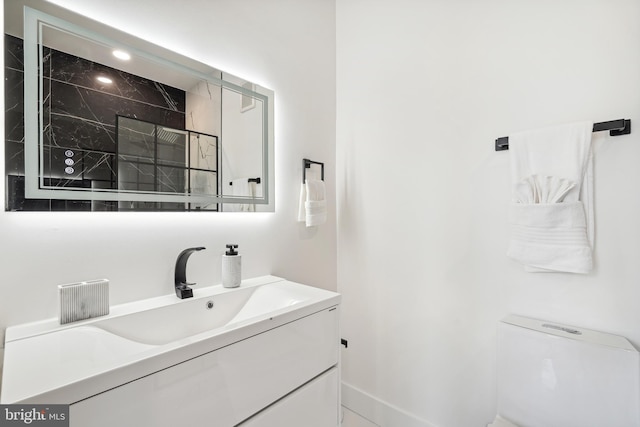 bathroom featuring vanity, toilet, and a tile shower