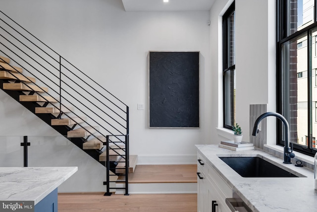 kitchen with white cabinets, plenty of natural light, and light hardwood / wood-style flooring