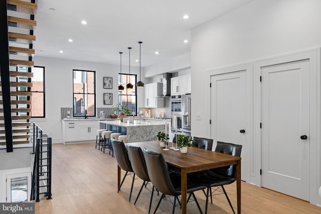 dining space with sink and light hardwood / wood-style floors