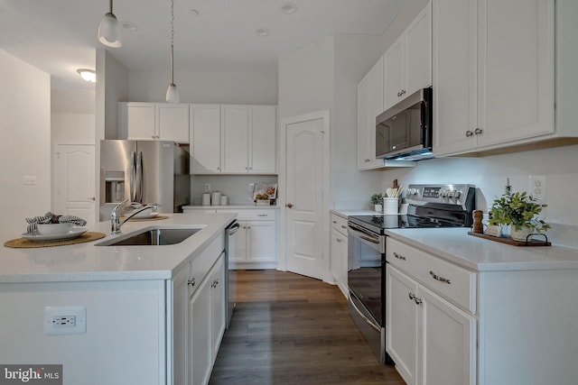 kitchen featuring white cabinetry, sink, pendant lighting, dark hardwood / wood-style floors, and stainless steel appliances