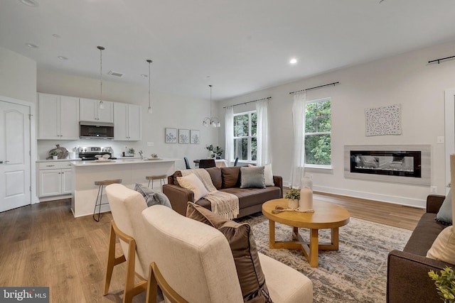 living room with light hardwood / wood-style flooring and a notable chandelier