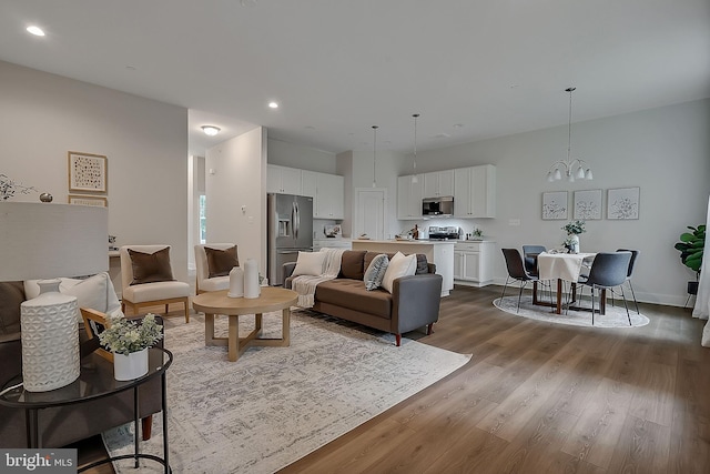 living room featuring a chandelier and wood-type flooring