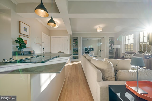 kitchen featuring light hardwood / wood-style floors, pendant lighting, ornamental molding, and beam ceiling