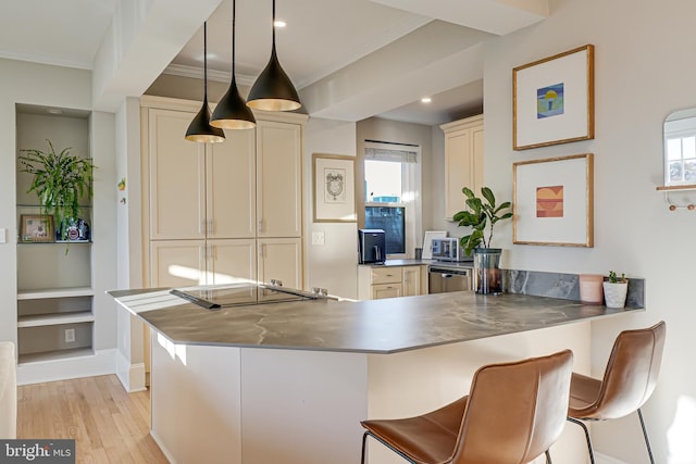 kitchen featuring decorative light fixtures, kitchen peninsula, a kitchen breakfast bar, built in shelves, and cream cabinetry