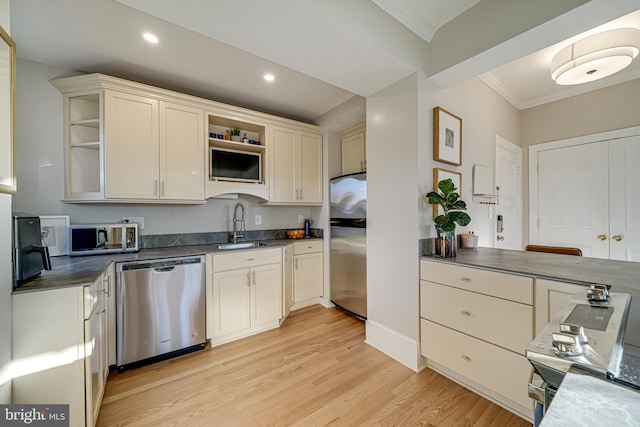 kitchen featuring cream cabinetry, appliances with stainless steel finishes, crown molding, light hardwood / wood-style flooring, and sink