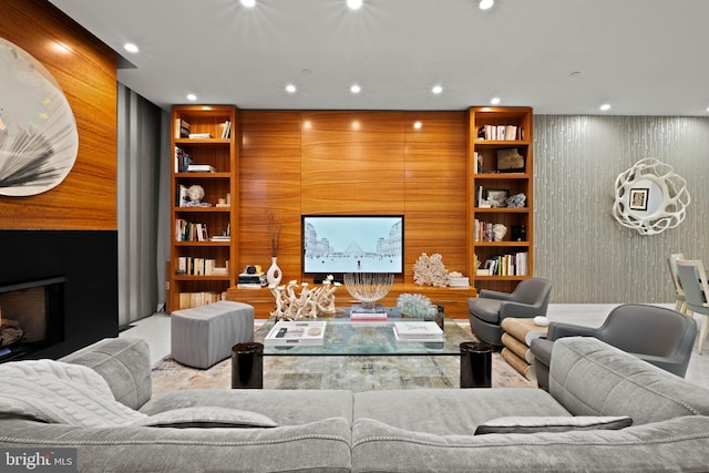 living room featuring built in features and wooden walls