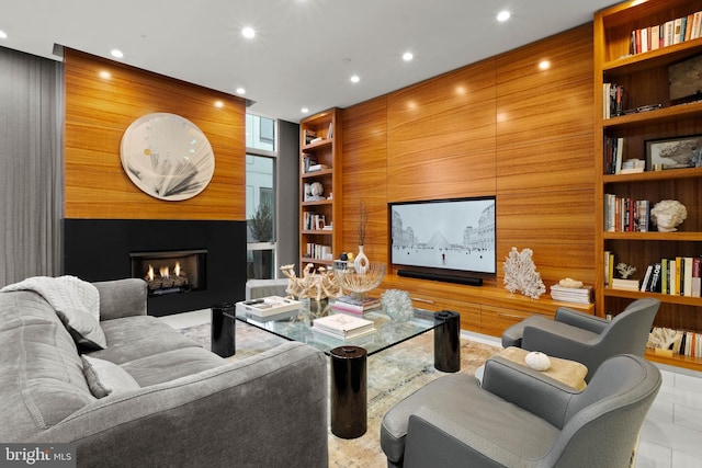 tiled living room featuring built in shelves and wooden walls