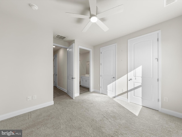 unfurnished bedroom featuring connected bathroom, light carpet, and ceiling fan