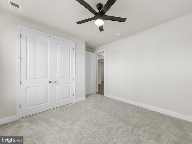 unfurnished bedroom with a closet, ceiling fan, and light colored carpet