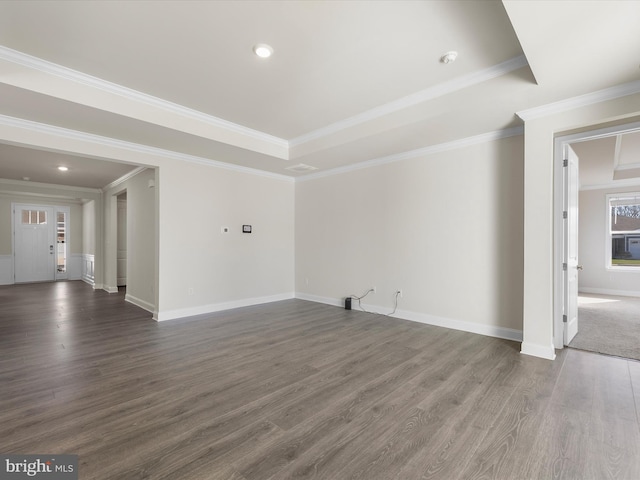 unfurnished living room featuring dark wood-type flooring, crown molding, and a raised ceiling