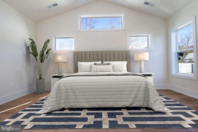 bedroom featuring multiple windows, dark wood-type flooring, and vaulted ceiling