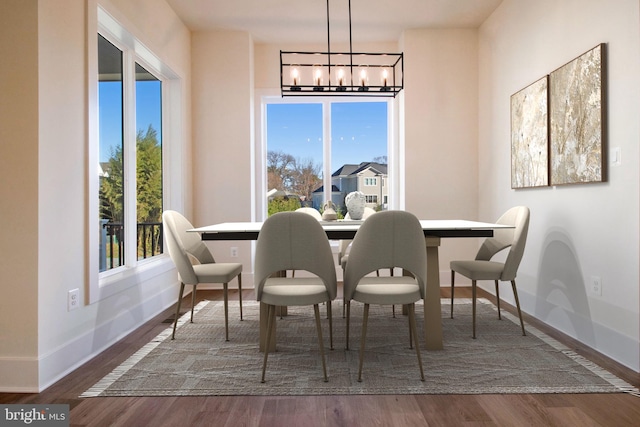 dining space with wood-type flooring and a notable chandelier