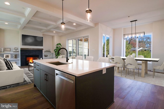 kitchen with pendant lighting, dishwasher, a center island with sink, sink, and dark hardwood / wood-style flooring