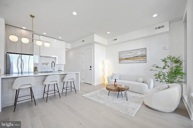 living room featuring light wood-type flooring and sink