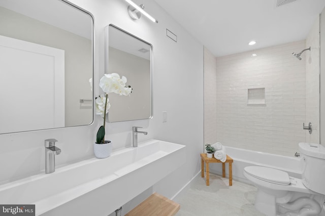 bathroom with tiled shower / bath and toilet