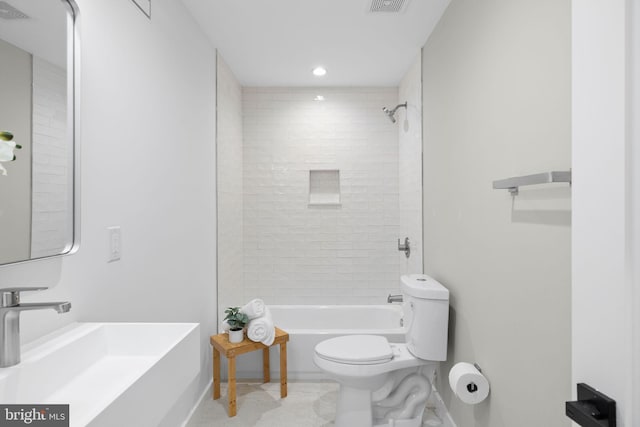 full bathroom featuring toilet, tiled shower / bath combo, and sink