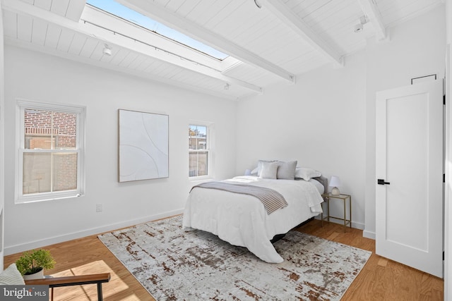 bedroom featuring hardwood / wood-style floors, wood ceiling, multiple windows, and beam ceiling