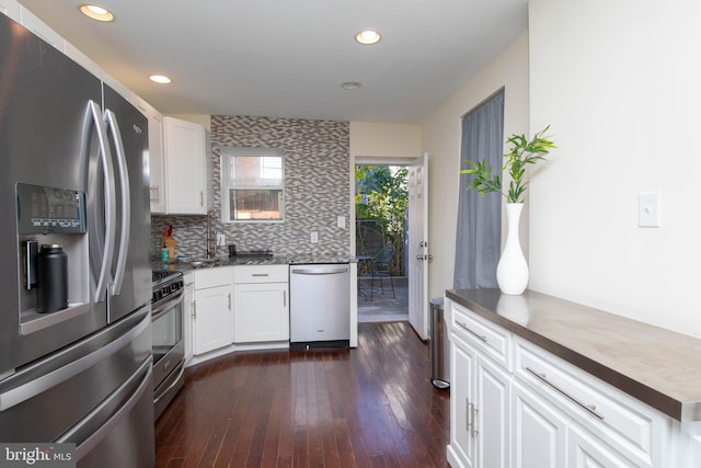 kitchen with white cabinetry, sink, stainless steel appliances, dark hardwood / wood-style flooring, and backsplash