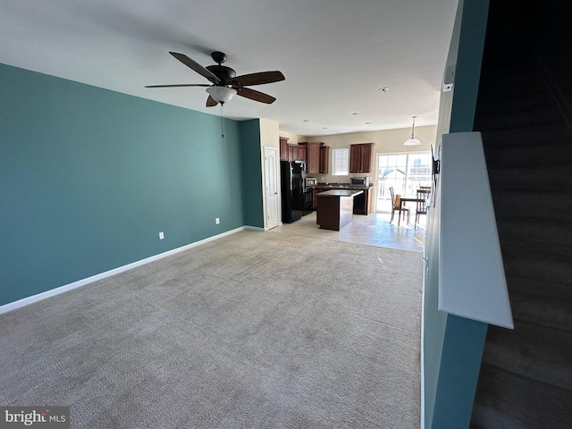 unfurnished living room with ceiling fan and light colored carpet