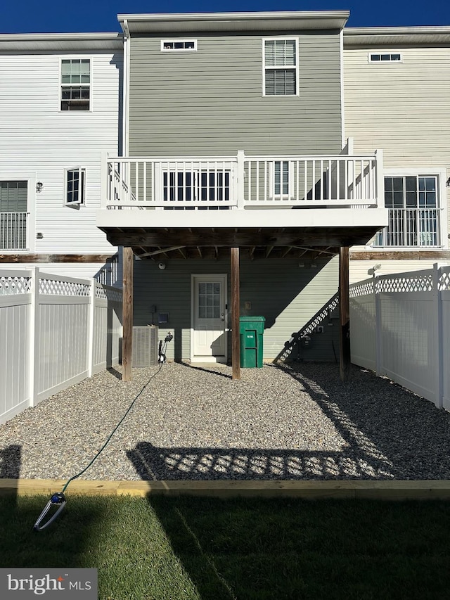 rear view of house with cooling unit and a deck