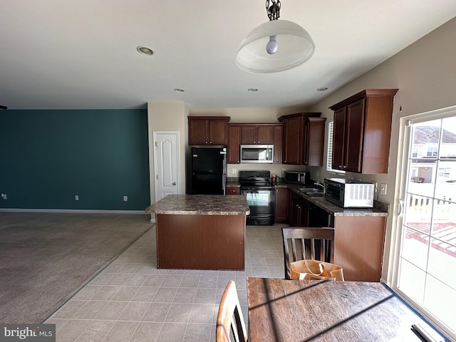 kitchen featuring black appliances, a kitchen island, sink, and light carpet