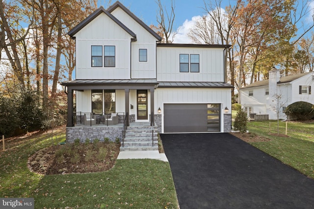 modern farmhouse featuring a front lawn, a porch, and a garage