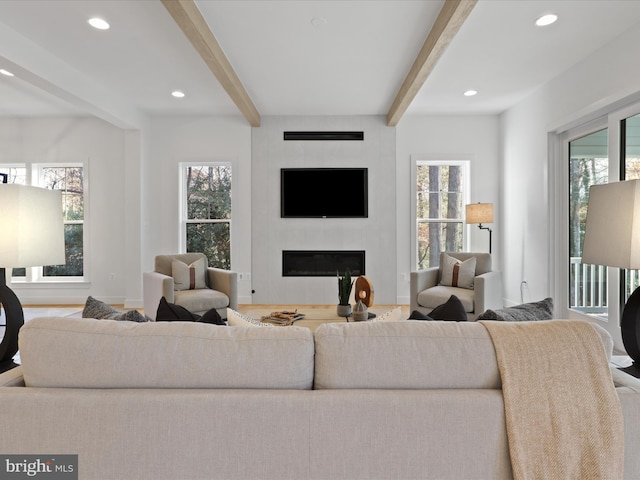 living room featuring beamed ceiling and a fireplace