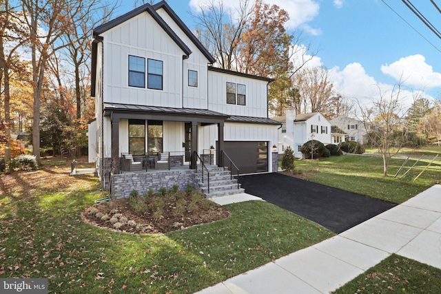 modern farmhouse style home featuring covered porch, a garage, and a front lawn