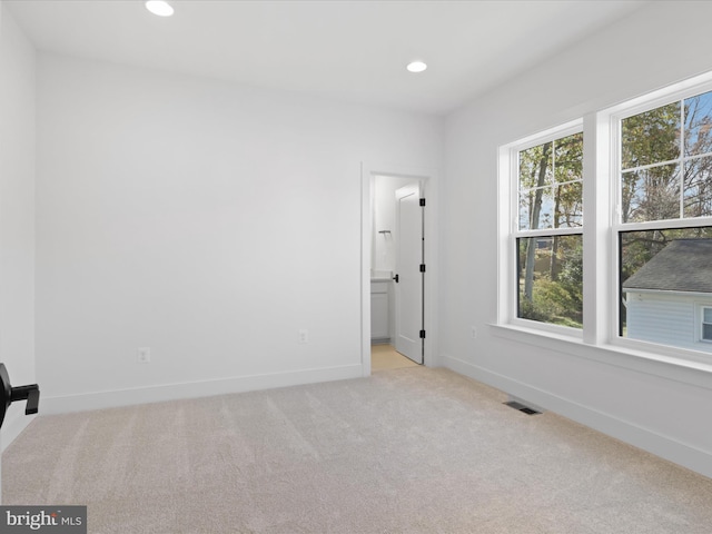 unfurnished room featuring light colored carpet