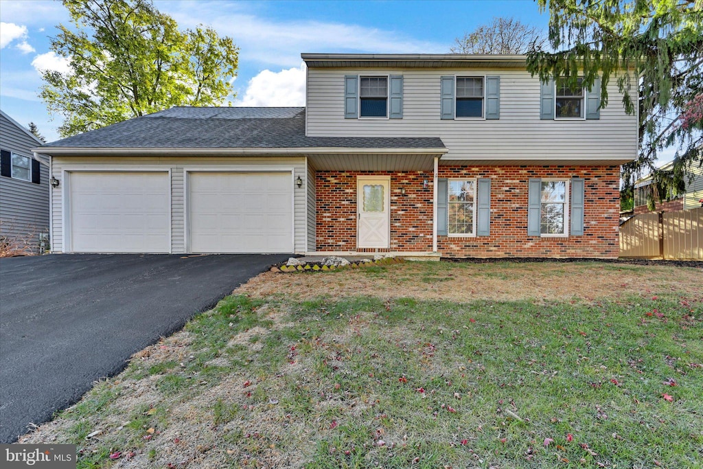 front of property featuring a front yard and a garage