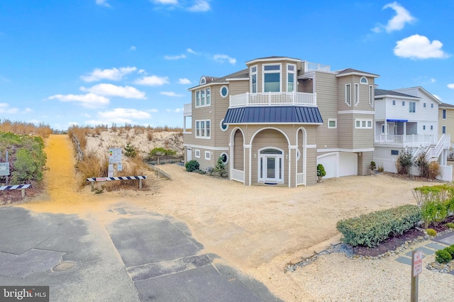 view of front of property featuring a garage and a balcony