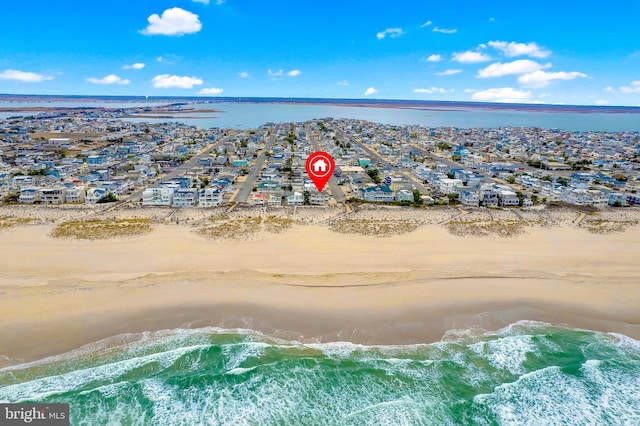 birds eye view of property featuring a beach view and a water view