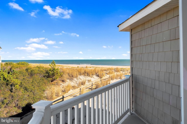 balcony featuring a beach view and a water view