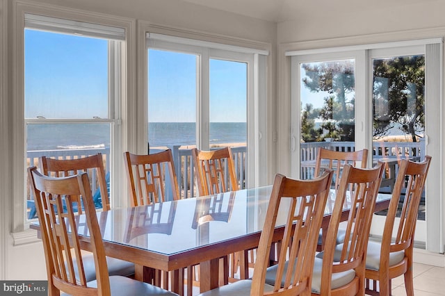 tiled dining room featuring a water view