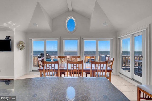 tiled dining room featuring lofted ceiling with beams, a water view, and plenty of natural light