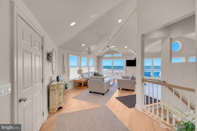 living room with light hardwood / wood-style flooring, ceiling fan, and lofted ceiling