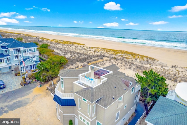 drone / aerial view featuring a water view and a beach view