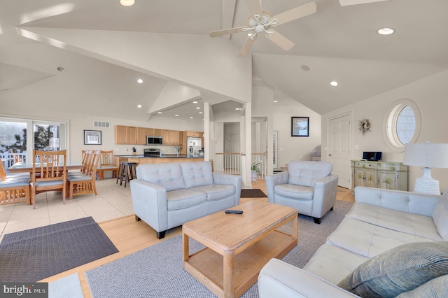 tiled living room featuring ceiling fan and high vaulted ceiling