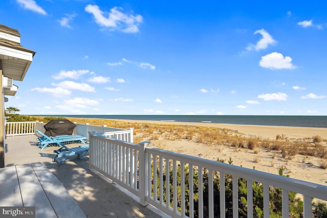 view of patio / terrace featuring a water view and a beach view